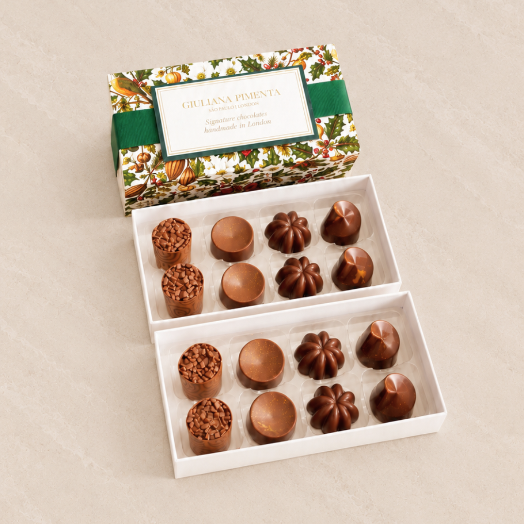 Sixteen chocolates in an open box with a forest-green ribbon, four flavours in the Orchard Selection